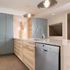 A soothing mix of natural wood and toned blue cabinets keep this kitchen bright and modern.  Can you guess where the existing ductwork is concealed?