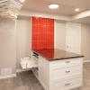 The laundry room island conceals lots of function - flat drying racks, storage for cleaners and laundry products.  The tall accent of red tile conceals storage for the ironing board and iron.
