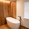 This bathroom is inspired by Scandinavian minimalism.  The beautiful wood accent wall and floor is actually tile!