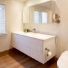 The bright, custom vanity floats above the floor, and together with the wide back-lit medicine cabinet, provides plenty of storage.